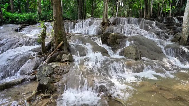 Pha Tat Waterfall, Kanchanaburi Province, Thailand. Video of a large waterfall in the middle of a lush green forest, with the sound of the waterfall. 4k