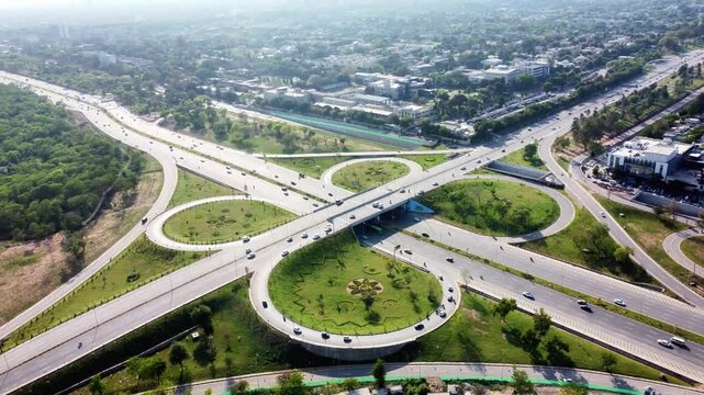 Aerial View of Cloverleaf Highway Interchange Surrounded by Urban Green Spaces