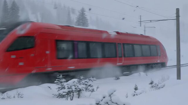 High speed red train through snowy winter landscape in motion