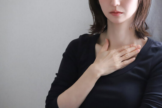 胸に手を当てる女性