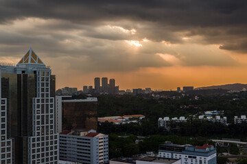 Golden sunset light illuminating buildings and greenery of Kuala Lumpur city