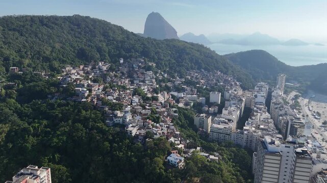 Drone flyover of Babil&ocirc;nia favela with Sugarloaf Mountain, Rio de Janeiro (slow)