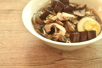 Fototapeta premium vermicelli thin rice noodles with pork and entrails topping egg yolk in soup on bowl