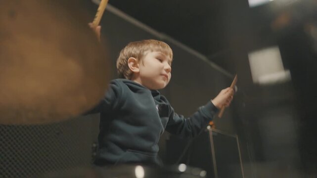 Young talented boy playing drums in studio