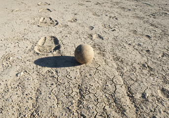 Beige ball on cracked earth
