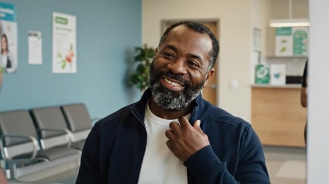 Portrait of a happy and healthy middle-aged African American man smiling in a hospital waiting room.