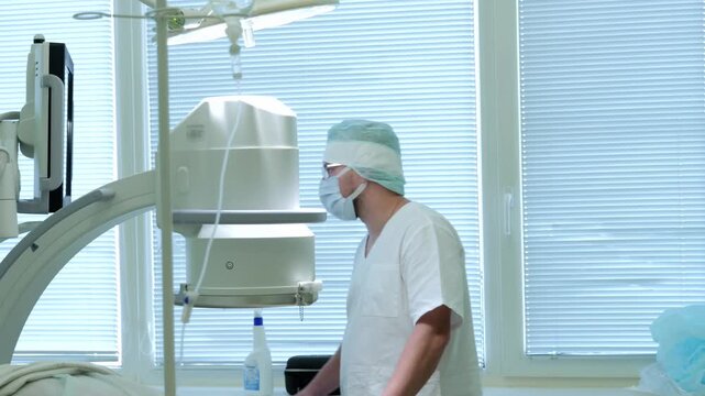 Russia Tomsk 05.07.2025: Surgeon concentrates on realtime imaging output during procedure meticulously, Medical team assesses fluoroscopic results on monitor to ensure accurate surgical