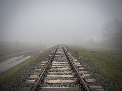 Via de tren en un paisaje de niebla