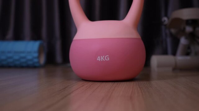 Close-up of a 4kg rubber coated kettlebell being lifted and dropped for weight inspection, testing durability and quality of fitness equipment, gym gear inspection concept.