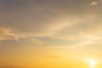 Fototapeta premium Beautiful sunset sky with soft orange and purple clouds background,Panoramic view of dramatic evening sky during sunset. Vibrant orange light on the horizon blending with soft purple and blue tones.