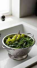 Fresh Green Grapes and Arugula in a Metal Colander on a Bright Kitchen Sink