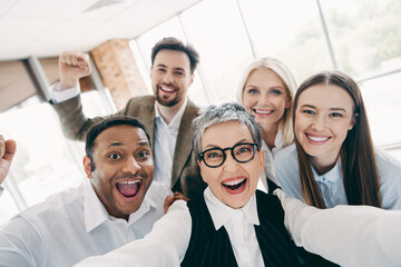 Obraz premium Group of happy business colleagues in office celebrating teamwork achievements and building strong work relationships