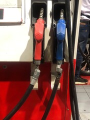 Fuel pumps at gas station red and blue nozzles.