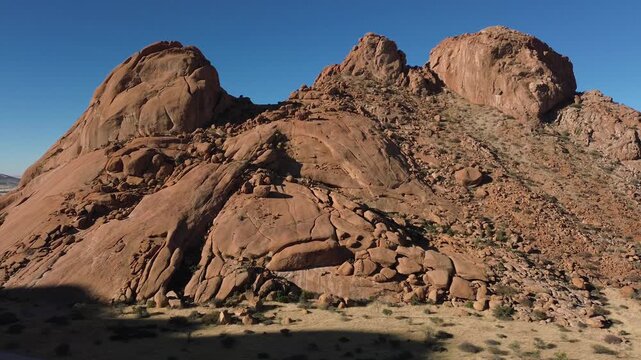 Spitzkoppe, or Spitzkop, is a unique pink granite rock formation in the landscape of Damaraland, Namibia, Africa. Aerial view.