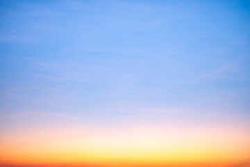 Fototapeta premium Sunset or sunrise sky with a vibrant gradient of orange, gold, and soft blue. Clear atmosphere with wispy clouds. Peaceful, natural light background. hope, freedom, new day and inspirational Concepts