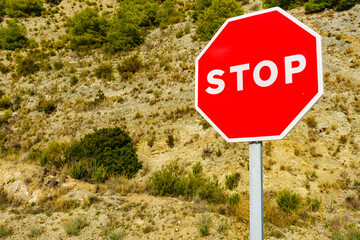 Stop sign by the road in mountains