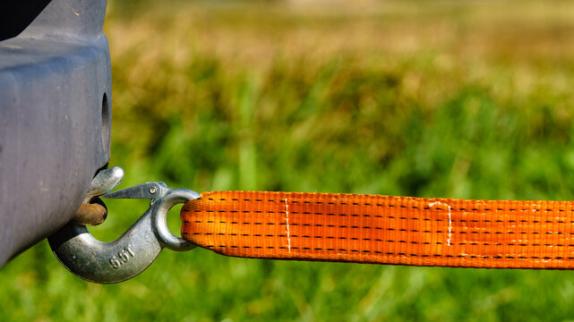 Tow hook with orange strap on car. Towing equipment.