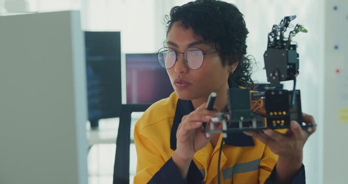 Young Black female engineer coding AI robot arm in modern laboratory. Robotics, artificial intelligence, technology, stem, future, innovation, diversity, automation, machine learning concept.