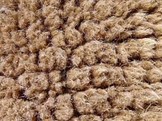 Macro Texture of Natural Coir Fiber Mat - Detailed Background of Coarse Brown Coconut Husk Bristles and Handwoven Rug Material Surface