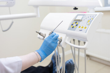 the dentist's hand puts the instrument back on the device