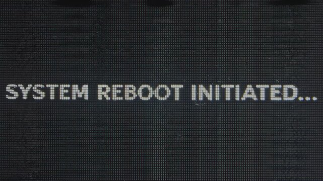 Digital screen displaying system messages indicating low memory, reboot initiation, and confirmation of reboot process in a dark technological environment, hdr video with neutral color