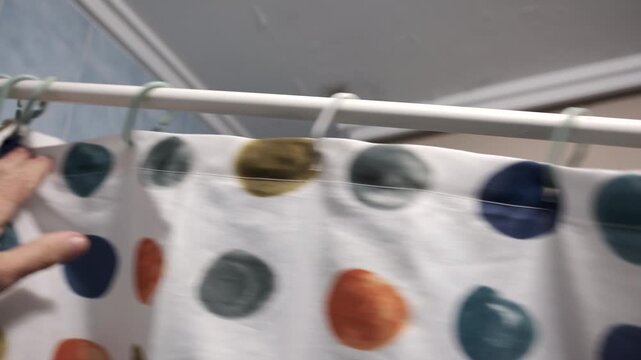 Hand opening and closing a shower curtain