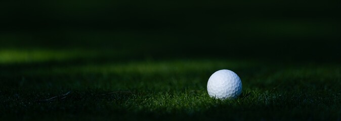 Golf ball on golf course near hole with flagstick in morning sunshine. view from above, close up,  © Angelov
