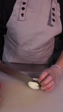 The cook cuts boiled eggs for salad. We prepare healthy meals