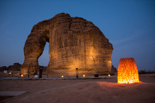 Elephant Rock iconic natural monument shaped by erosion near Al Ula in Saudi Arabia with an atmospheric lamp in the foreground creating a warm desert mood