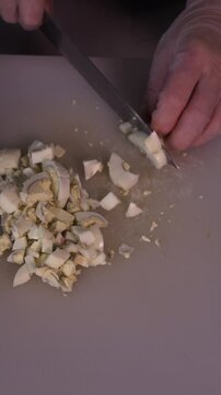 The cook cuts boiled eggs for salad. We prepare healthy meals