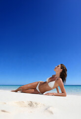 Woman on the beach in white bikini