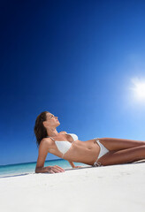 Woman on the beach in white bikini