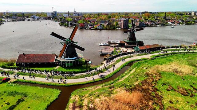 Aerial drone view of beautiful wooden windmills in the Dutch village of Zaanse Schans. The windmills run on wind. The Dutch canals are filled with water. Located near the city of Zaandam.