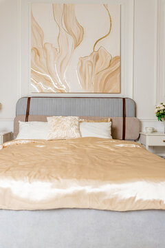 Pastel and beige bedding, soft pillows and fur coverlet. coziness, comfort, interior, holidays.luxury bedroom. Classical interior of beige bedroom with king size bed, pillows, plant and a plaid.