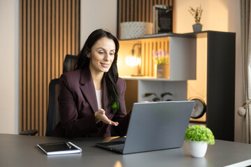 A happy executive is seen interacting with her laptop, showing engagement and professionalism at work.
