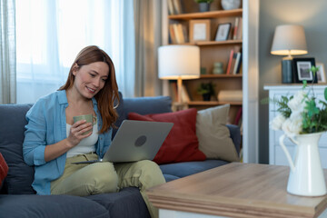 Obraz premium Woman relaxing at home using laptop computer