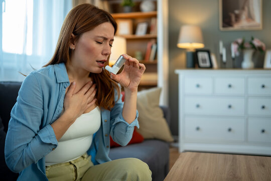Woman experiencing asthma attack using medical inhaler