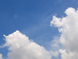 Obraz premium Afternoon sky filled with clouds, illuminated by the bright afternoon sun – White and grey clouds illuminated by the rays of the afternoon sun, amidst a blue sky.