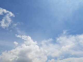 Obraz premium Afternoon sky filled with clouds, illuminated by the bright afternoon sun – White and grey clouds illuminated by the rays of the afternoon sun, amidst a blue sky.