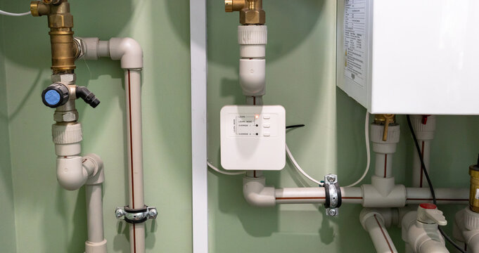 Modern home water leak protection system with a control module and valves. Ideal for plumbing, installation, maintenance, and smart home concepts.