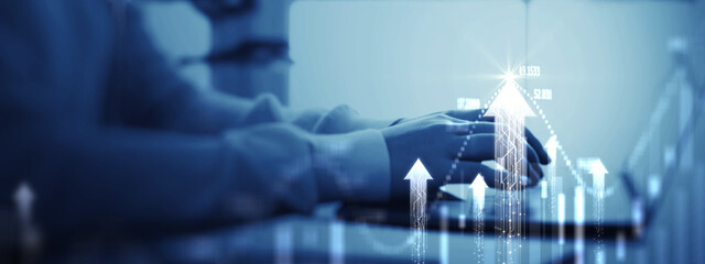 Close Up Of Businessman Hands Using Laptop With Glowing Blue growth Arrows And Financial Data Chart. Concept For Successful Business Strategy, Investment Profit, Digital Transformation, Stock Market.