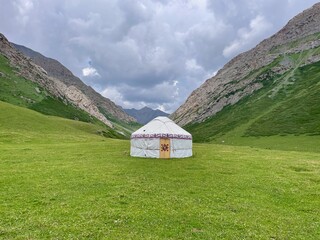 Traditional nomadic yurt close to Kol Tor Lake, Kyrgyzstan, set in a mountain landscape.