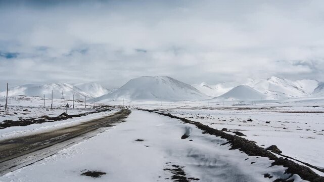 Snow covered mountain and dirt road on wilderness at Arabel Plateau, Kyrgyzstan