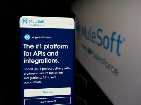 Stuttgart, Germany - 01-26-2026: Person holding cellphone with webpage of US integration software company MuleSoft LLC on screen in front of logo. Focus on center of phone display.