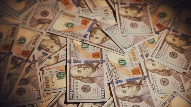 Close-up pile of one hundred American dollars on table dark room banknotes fall onto stack cash. High interest rates on mortgage loans. Payments to creditors, banks, debt collectors. Money laundering