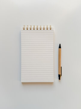 Empty note pad for making lists, notes and journaling with a pen on white table
