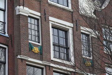Obraz premium Keizersgracht Canal House Facade Close Up with Sculpted Green and Yellow Decoration in Amsterdam, Netherlands
