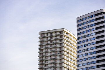 Fototapeta premium Modern residential apartment buildings in an urban area against a clear blue sky. Ideal for real estate, architecture, city living, and property development concepts.