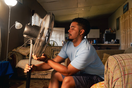 Young man finding coolness during hot day at home
