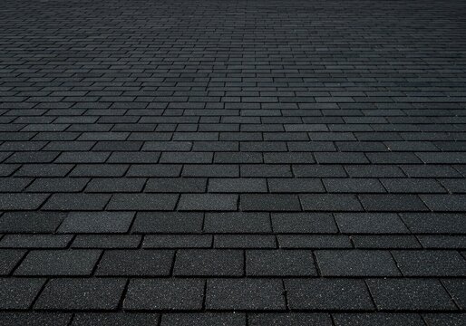 Architectural background texture of new black asphalt shingles arranged in a neat, repeating pattern for weather protection, building, domestic, structural